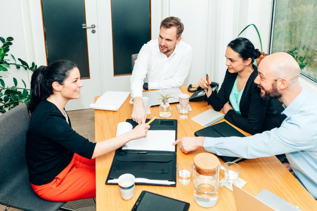 group of female and male colleagues working together as a team in a small office