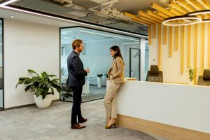 Professional Colleagues Engage in Conversation by the Reception in a Modern Office Setting