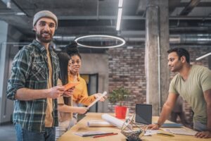 Bearded guy with tablet and colleagues in office