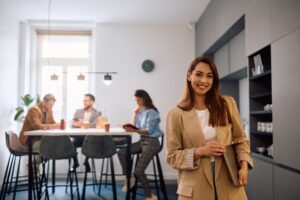Young happy businesswoman at casual office looking at camera.