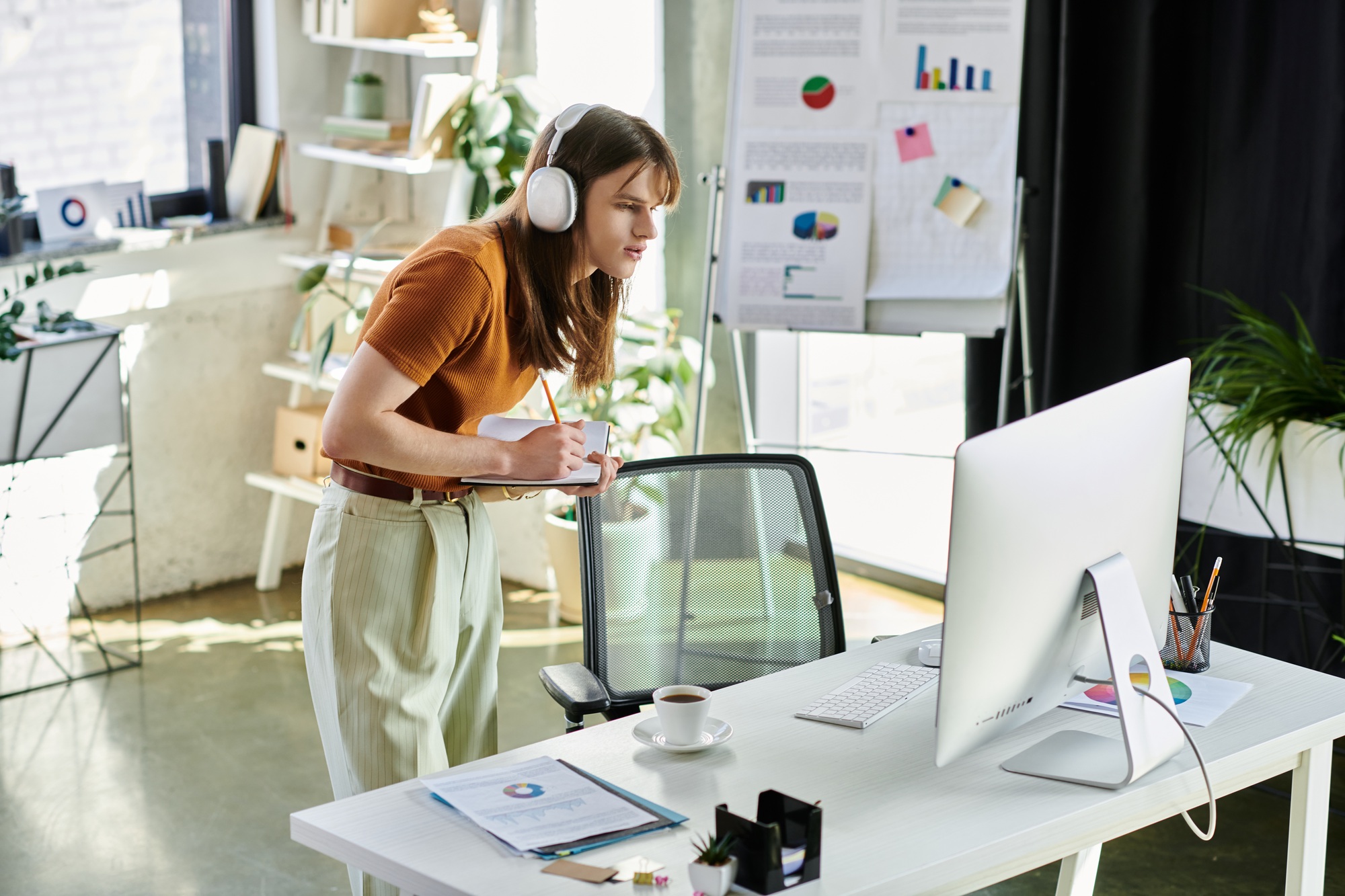 A young non binary individual engages creatively in an office workspace filled with inspiration