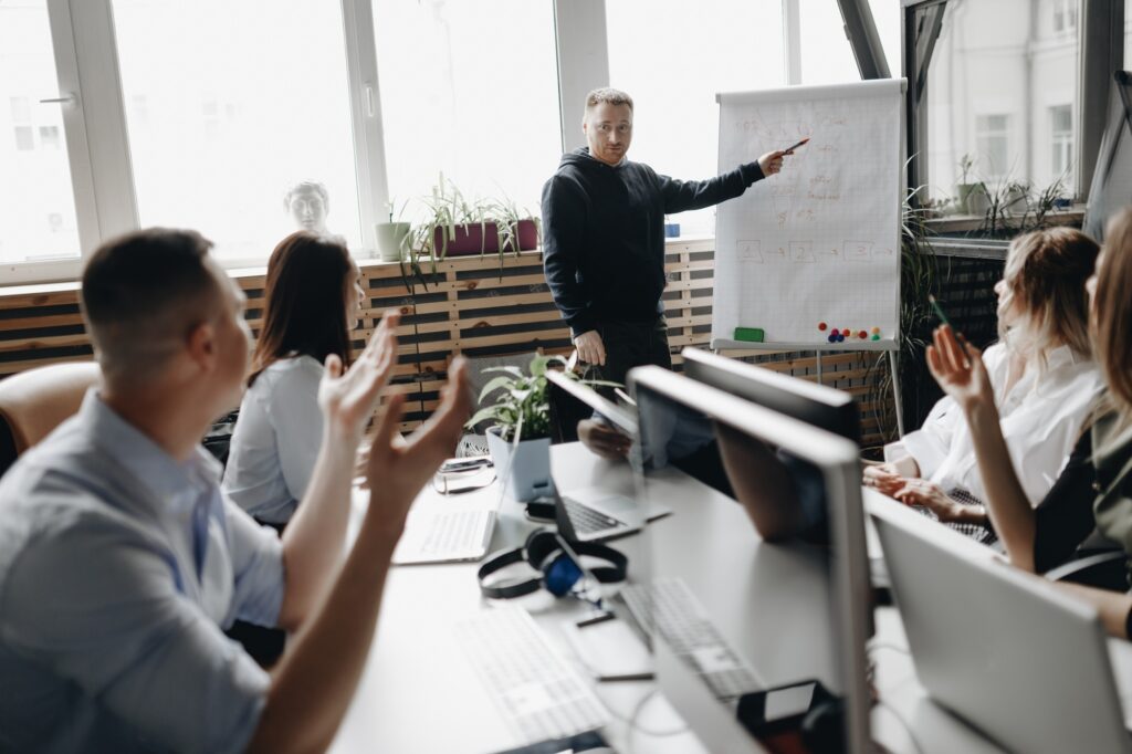 Staff meeting of a young successful team in the light modern office equipped with modern office