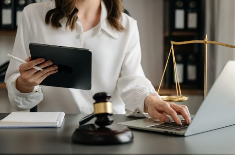 justice and law concept.Male judge in a courtroom the gavel, working with smart phone and laptop