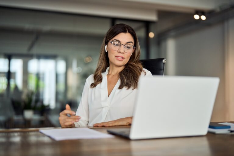 Mid aged business woman manager having hybrid meeting working in office.